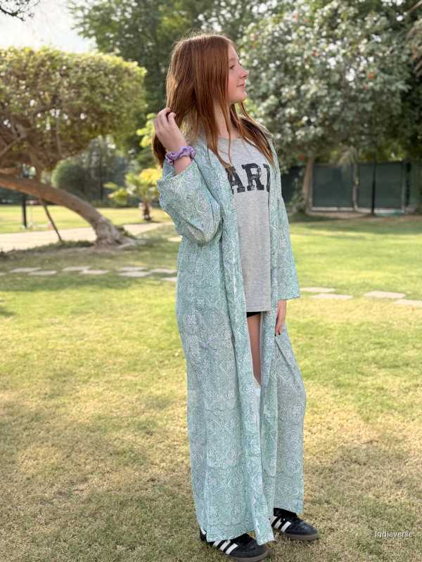 Woman in a light green dress standing in a park