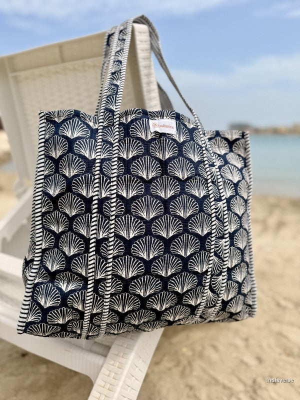 Tote bag with shell pattern on a beach chair by the ocean