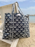 Tote bag with shell pattern on a beach chair by the ocean