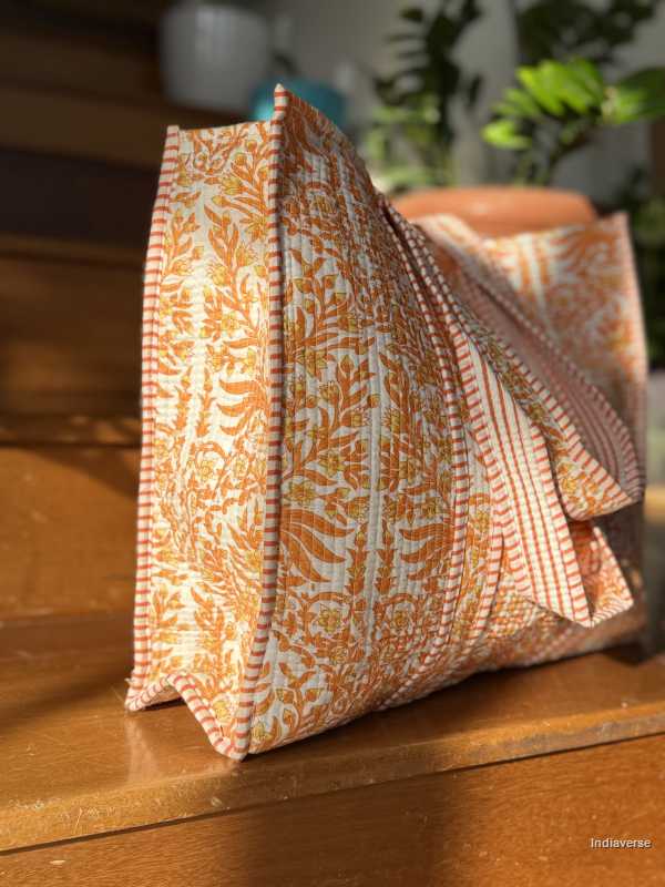 Cotton tote bag with orange and white pattern on a wooden surface