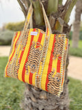 quilted tote bag with tiger print hanging from a tree branch