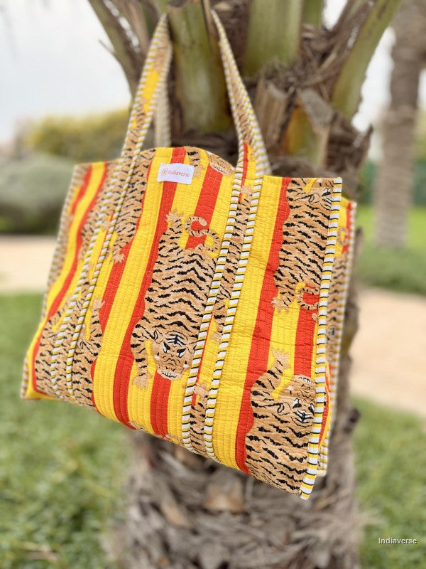 quilted tote bag with tiger print hanging from a tree branch