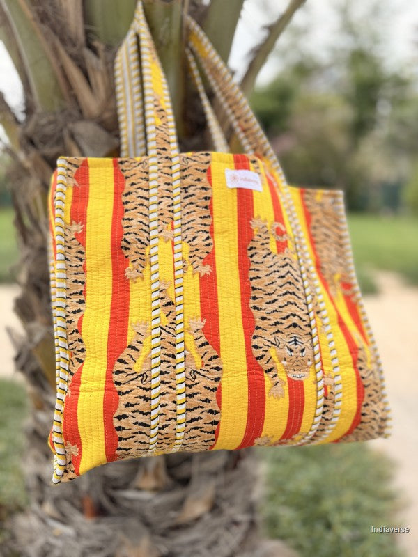 quilted bag with tiger print hanging from a palm tree