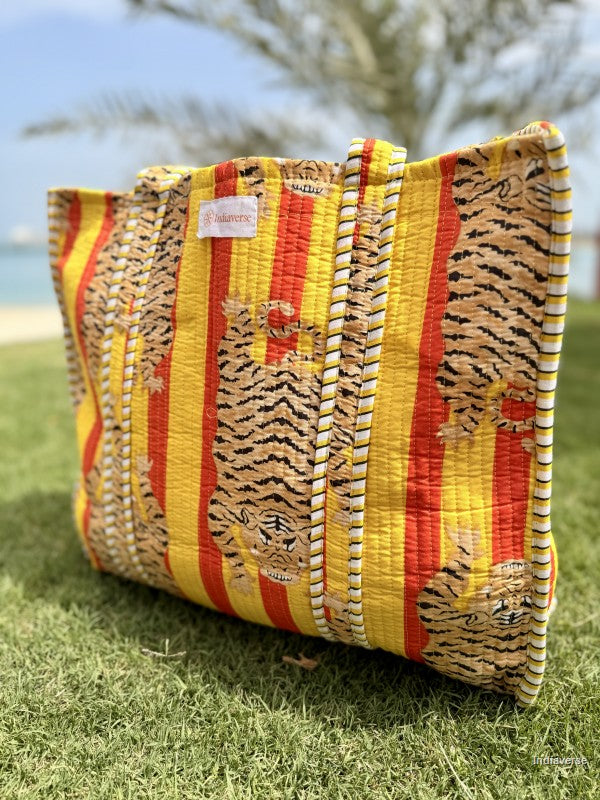 tote bag with tiger print on yellow and orange color sitting on the grass