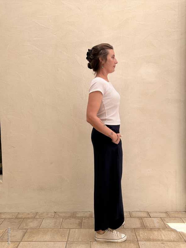 Person standing in a bathroom with tiled walls and floor.