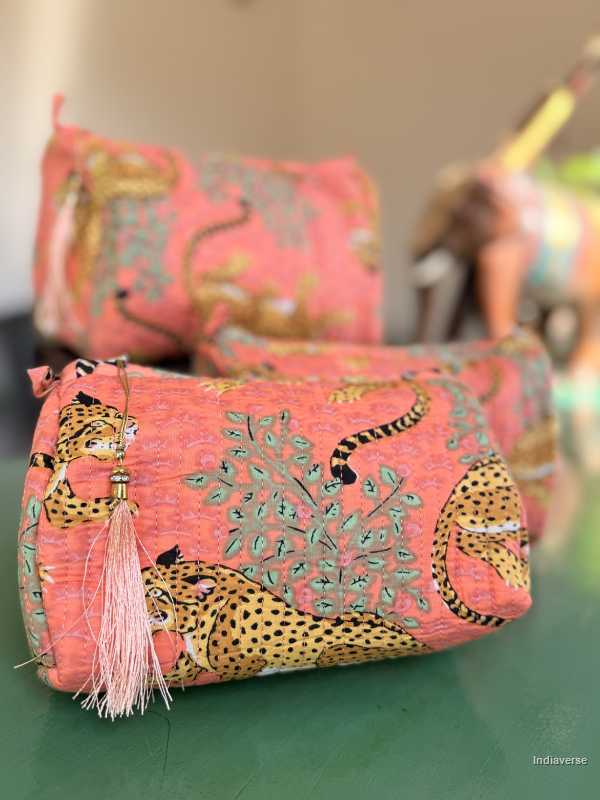 Pink pouch with leopard design and tassel on a green surface | Peach Leopard