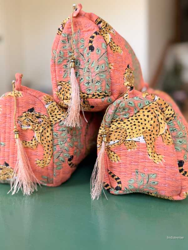 Pink bags with leopard designs and tassels on a green surface | Peach Leopard