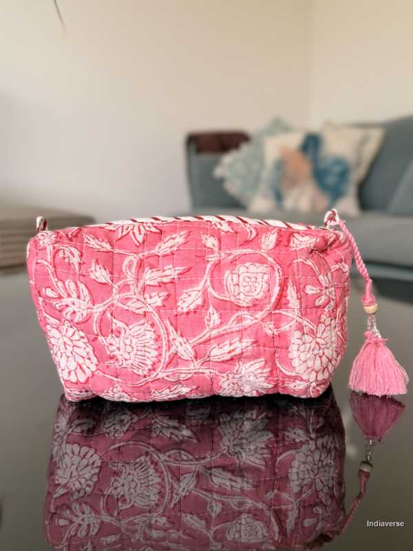 Pink floral-patterned bag with tassels on a reflective surface | Pink Delight