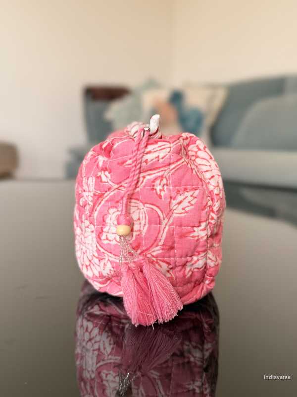 Pink decorative item with floral patterns on a reflective surface