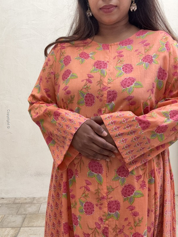 Woman wearing a floral patterned saree with a neutral background