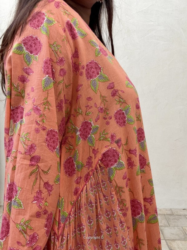 Person wearing a floral dress with pink and green flowers on a white background