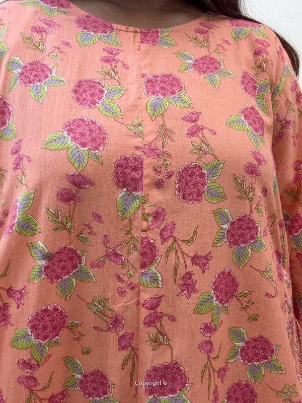 Floral patterned fabric with pink and green colors on a peach background