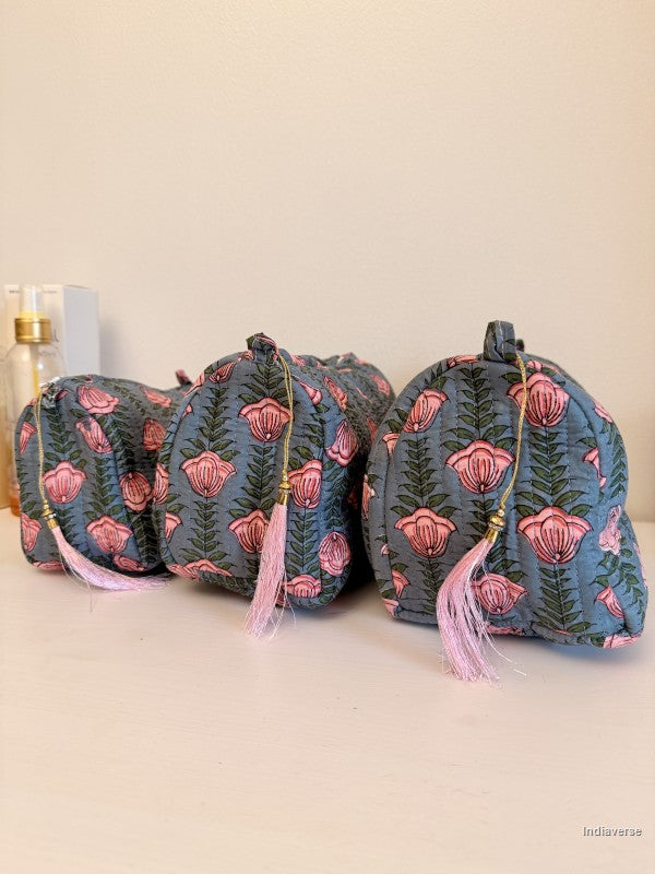 Three small drawstring pouches with a blue-gray floral print and pink tassels, arranged on a light surface against a plain beige background | Pink Lotus