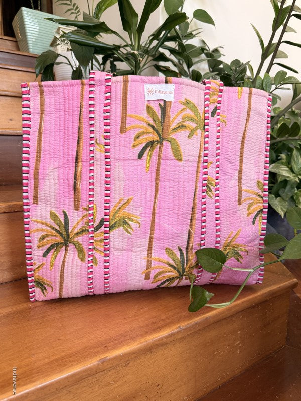 Pink fabric with palm tree design on a wooden surface