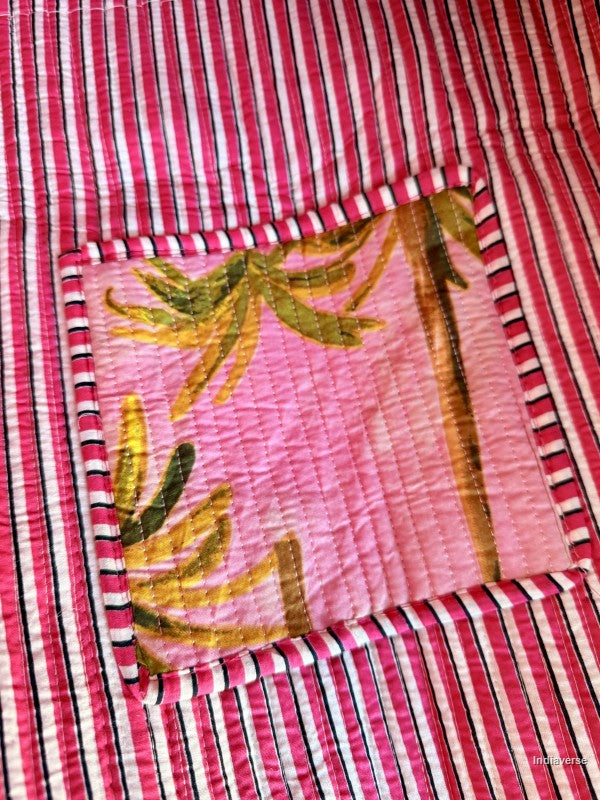 Close-up of a pink and red striped fabric with a floral pocket.