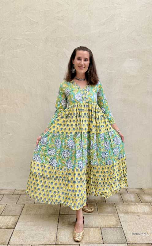 Woman wearing a floral dress standing against a beige wall.