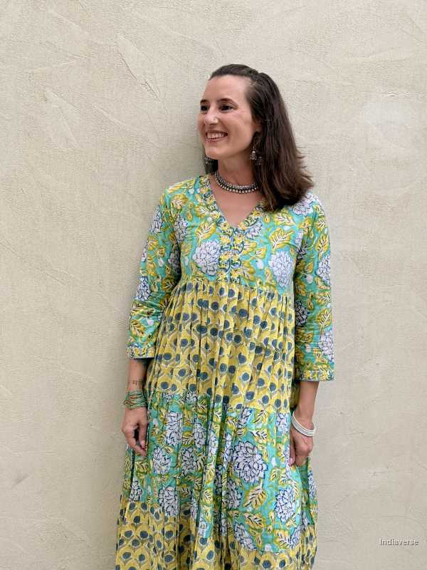 Woman wearing a floral dress standing against a beige wall