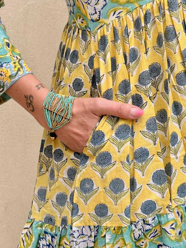 Yellow floral dress with a hand pointing to the pattern