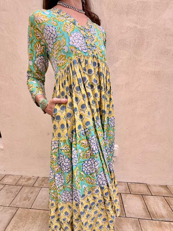 Woman wearing a floral dress with a yellow and blue pattern on a beige background