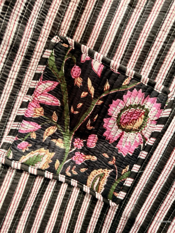 Embroidered fabric with floral patterns on a black and white striped background