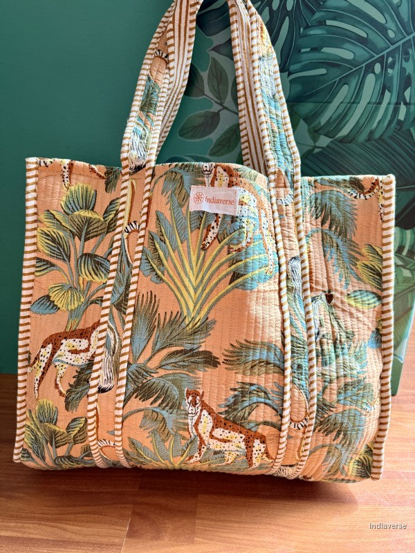 Tropical patterned bag with a visible brand label on a wooden surface and leafy background
