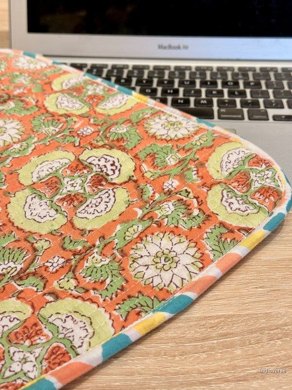 Floral-patterned laptop sleeve on a desk with a laptop in the background