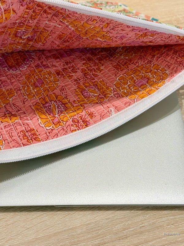 Close-up of a pink floral fabric pouch with a white interior on a wooden surface.