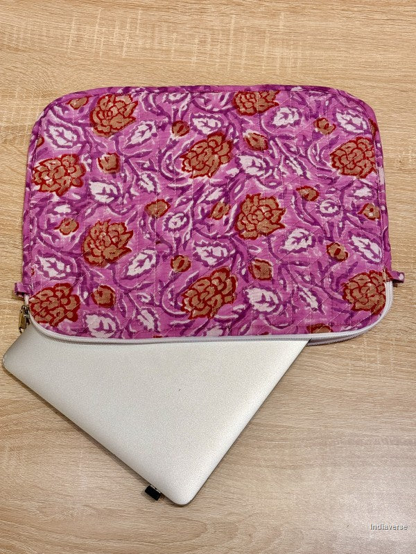 Pink floral laptop sleeve on a white laptop on a wooden surface