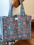 beautiful hand block printed quilted cotton tote bag with water inspired floral design perfect tot carry all your essentials hanging on wooden staircase railing