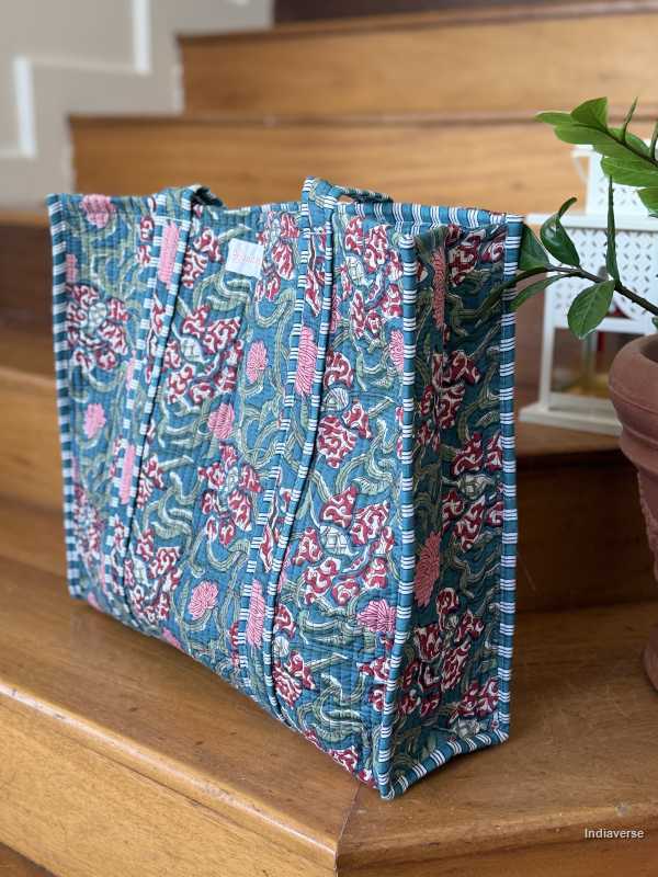 beautiful hand block printed quilted cotton tote bag with water inspired floral design perfect tot carry all your essentials sitting on wooden staircase