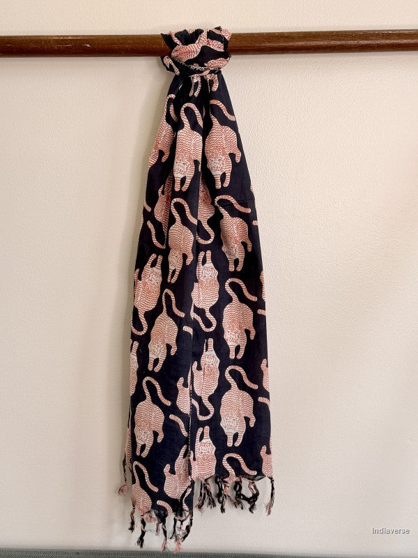 black cotton scarf with red tiger print tied to a wooden beam