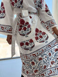 White garment with red floral patterns in a desert setting
