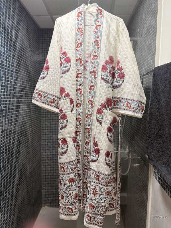 Floral patterned robe hanging against a tiled bathroom wall.