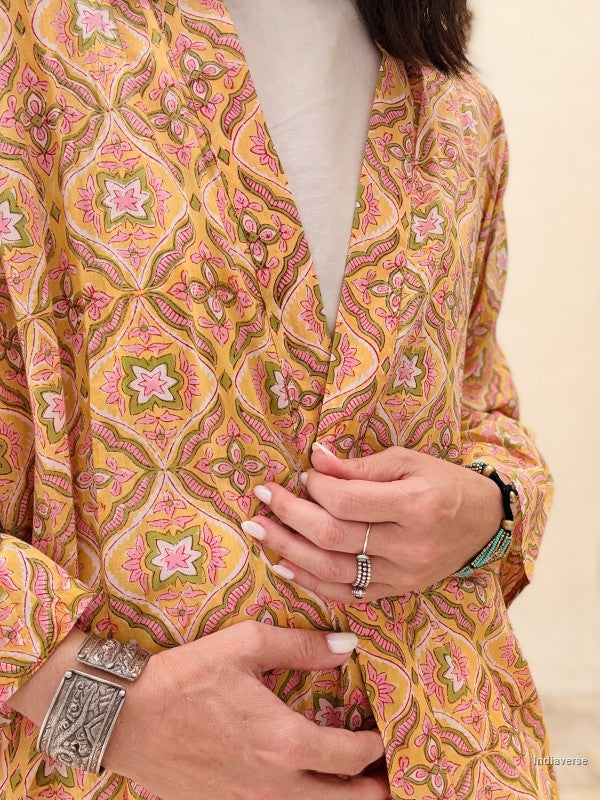 Close-up of a person wearing a patterned garment with hands clasped together.