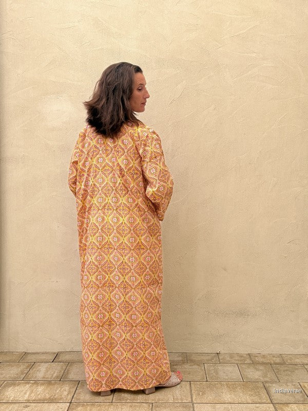 woman wearing a long abaya robe with geometrical yellow pattern