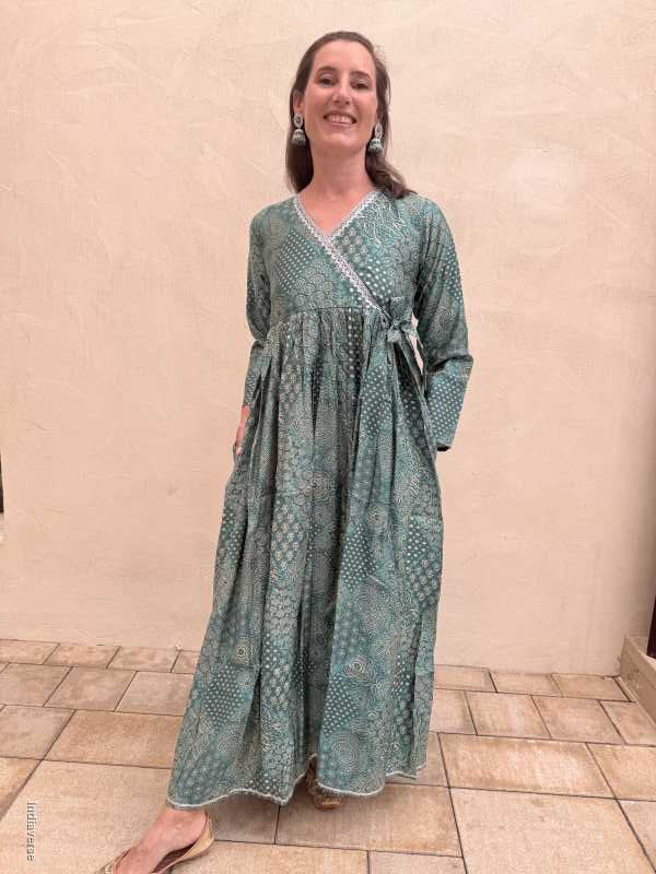 Person wearing a long, patterned dress standing on a tiled floor.
