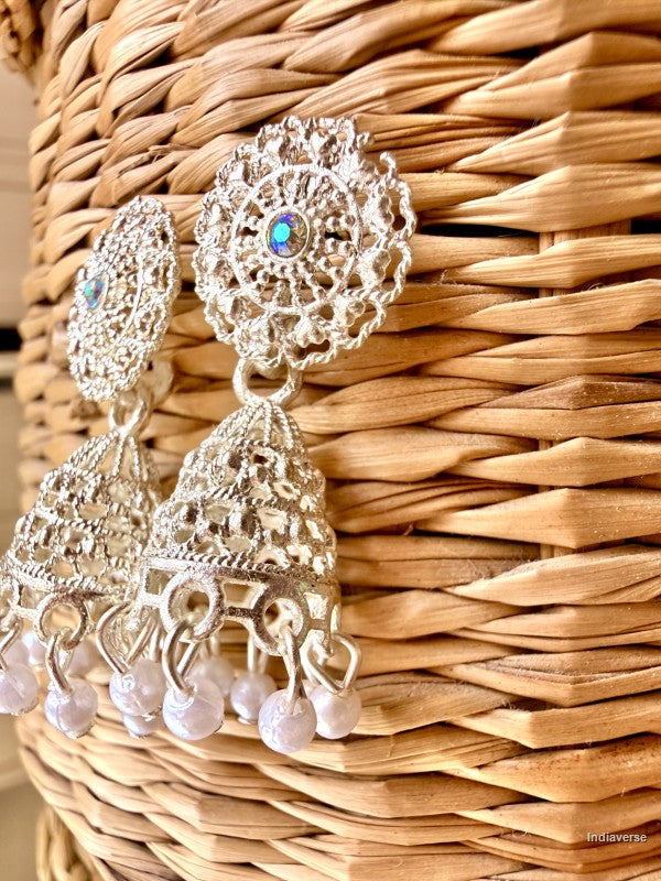 small silver white earrings hanging n a wicker basket