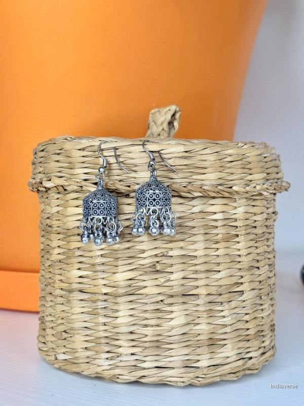 silver earrings dangling from a small woven basket