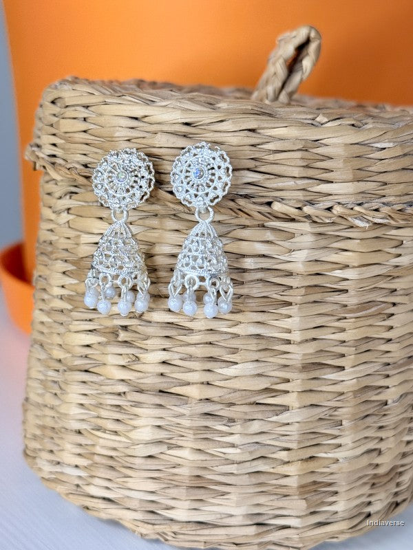 silver earrings with tiny pearls at the base hanging from a woven basket