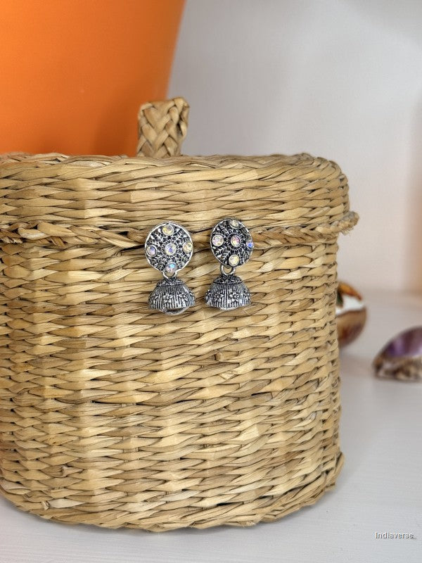 Silver earrings on a woven basket with a blurred background