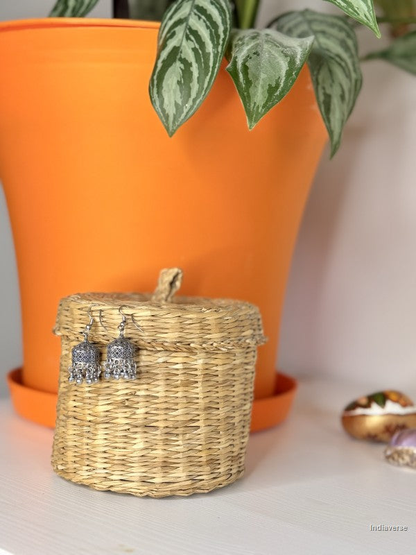 small zinc oxide earrings in plain silver look hanging from a wicker basket