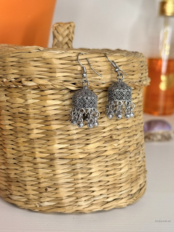 Silver earrings on a woven basket with a blurred background