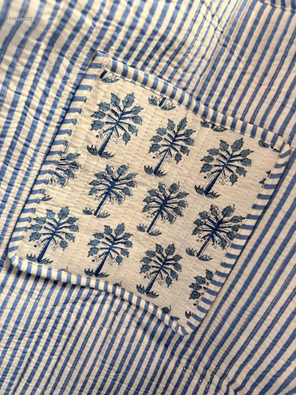 Close-up of a fabric pocket with blue floral pattern on a striped background
