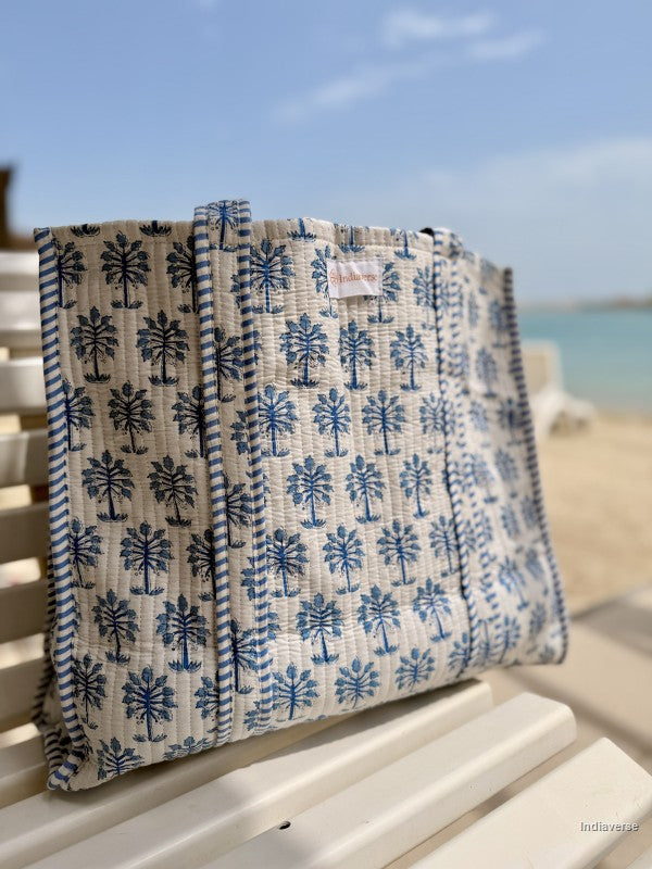 Blue and white patterned bag on a chair with a beach background