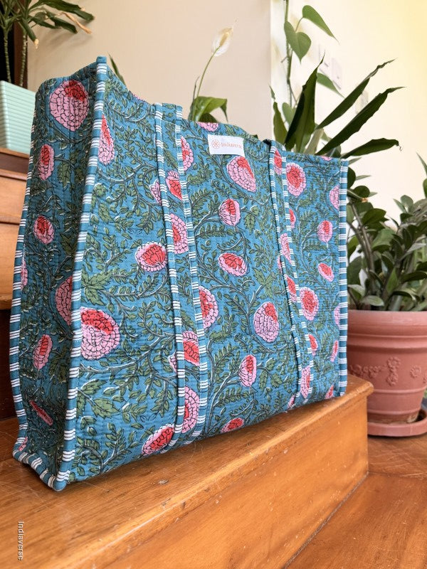 side view of a cotton tote bag with floral design sitting on a wooden surface
