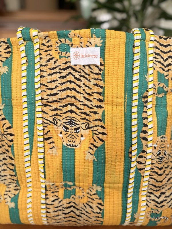 Large tote bag with tiger pattern and brand label on a wooden surface