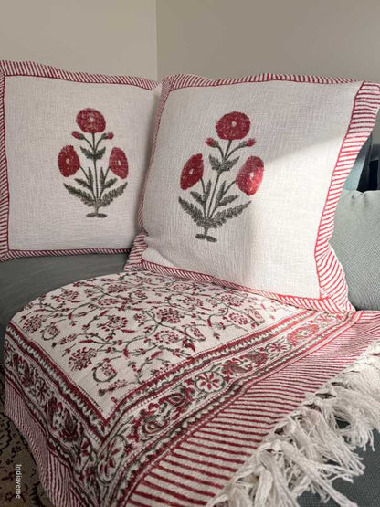 Decorative pillows with floral patterns on a neutral background with matching throw