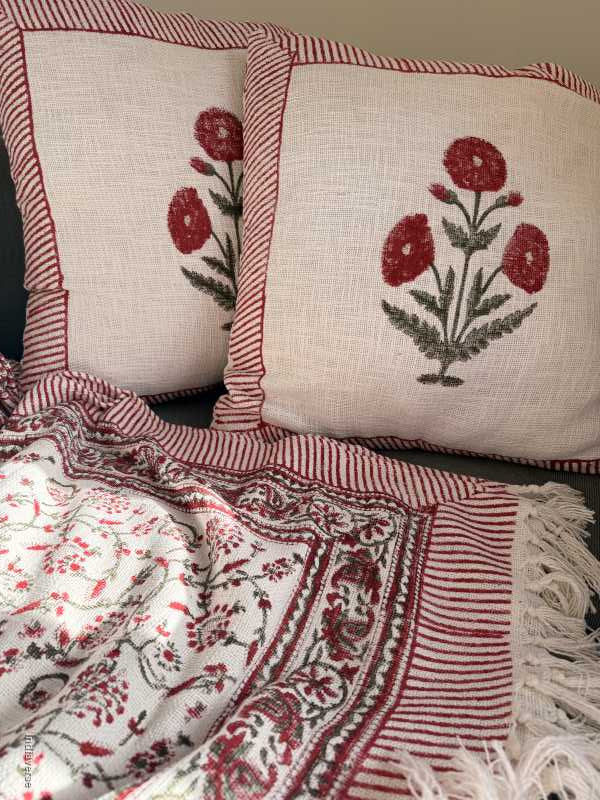 large cushions with flower pattern with matching throw blanket on couch