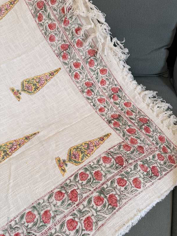 Decorative fabric with floral and geometric patterns on a gray surface