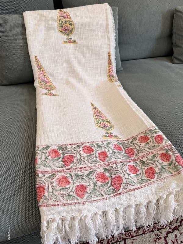 White saree with floral patterns draped over a gray surface